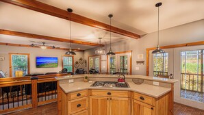 A spacious kitchen with wooden cabinets, a large island, and pendant lighting. - Mountain View Escape-Dog friendly, Screened Porch (Dahlonega)