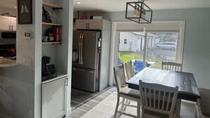 Una cocina compacta con refrigerador, microondas y un comedor con mesa y sillas.