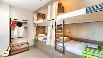 Ein Schlafzimmer mit Etagenbetten, einer Gitarre, einer Bank und einem Kleiderständer.
