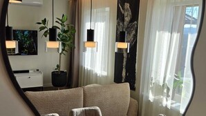 Een moderne eethoek met een houten tafel en stoelen, hanglampen en een plant in pot.