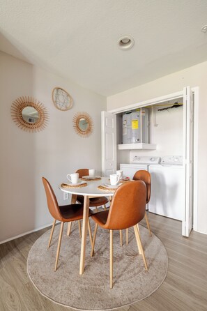 Un coin repas avec une table ronde, quatre chaises et un tapis rond.