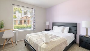 A bedroom with a bed, bedside tables, a desk, and a chair. - Cool 2Bed 1Bath 5 min walk to NRG & Medical Center (Houston)