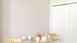 Un comedor con una mesa y sillas de madera, un banco y una puerta blanca al fondo.