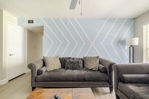 A living room with a sofa, a coffee table, and a lamp. - Central 3bed 2bath, 5 min Walk to NRG, near MDC (Houston)