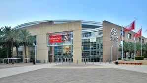 A modern building with a curved facade, large glass windows, and a prominent Toyota Center sign.