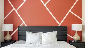A hotel room with a bed, two bedside tables, and a headboard.