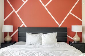 A hotel room with a bed, two bedside tables, and a headboard.
