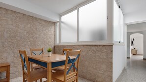 Un espace repas avec un mur en pierre, une table en bois et des chaises.