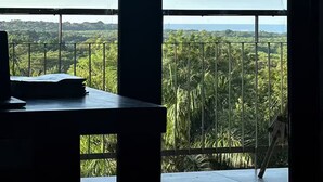 Una habitación con un amplio ventanal que da a un paisaje exuberante.