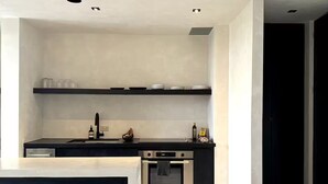 Una cocina moderna con encimera negra, electrodomésticos de acero inoxidable y un diseño minimalista.