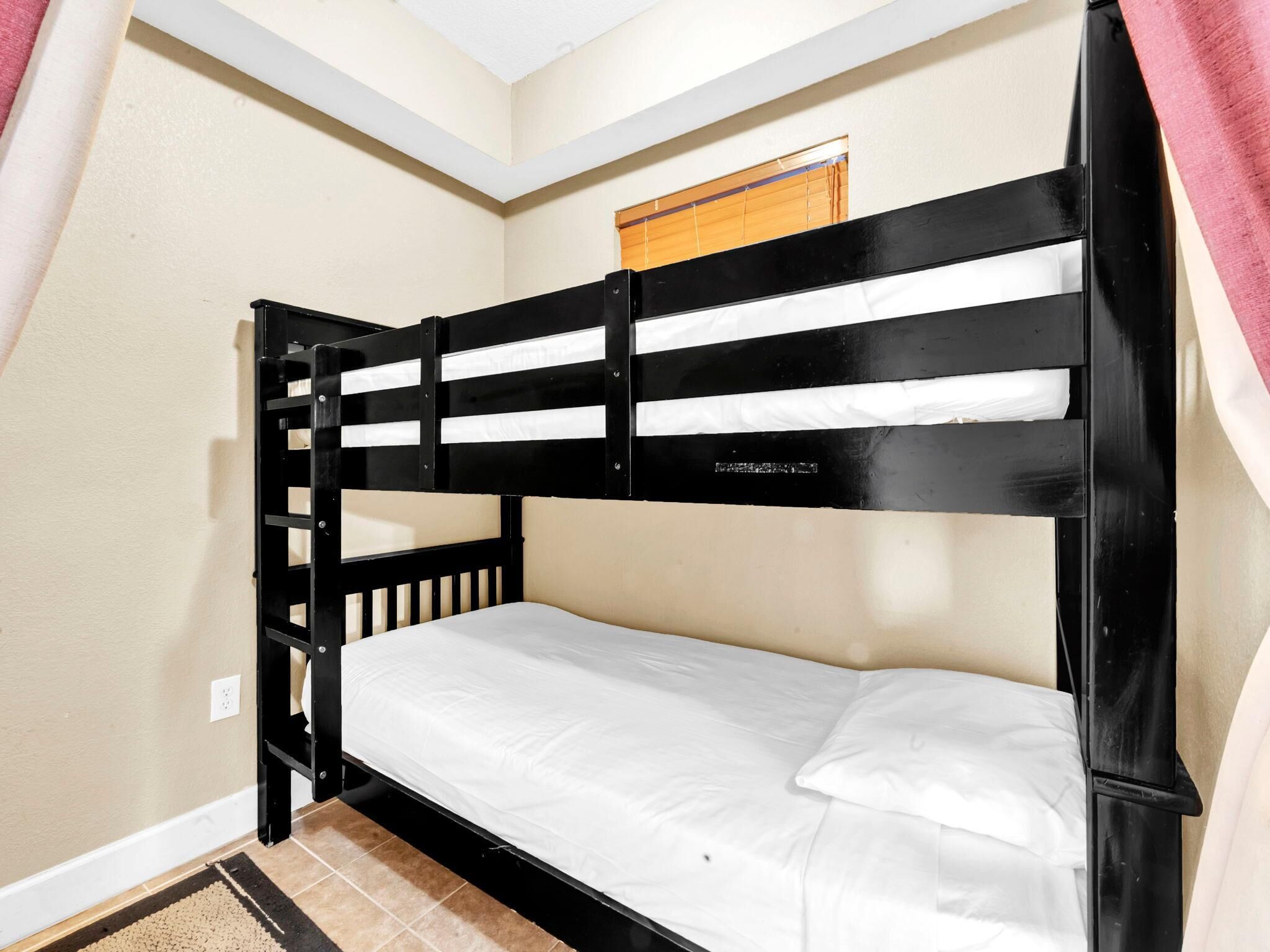 A bunk bed with a white mattress and a wooden headboard.