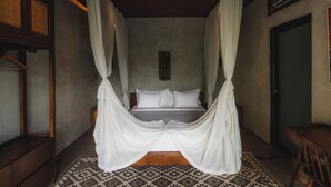 A four-poster bed with white drapes, a wooden bench, and a patterned rug in a room with a wooden ceiling and a green door. - Boutique 6-bedroom Villa The Wing in wonderful Ubud Bali incl. Concierge Service (Ubud)