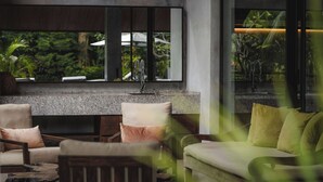 A modern bathroom with a granite countertop, a sink, and a mirror. There are two chairs and a sofa with cushions. - Boutique 6-bedroom Villa The Wing in wonderful Ubud Bali incl. Concierge Service (Ubud)