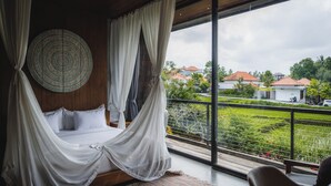 A bedroom with a large bed, white curtains, and a view of a green landscape through large windows. - Boutique 6-bedroom Villa The Wing in wonderful Ubud Bali incl. Concierge Service (Ubud)