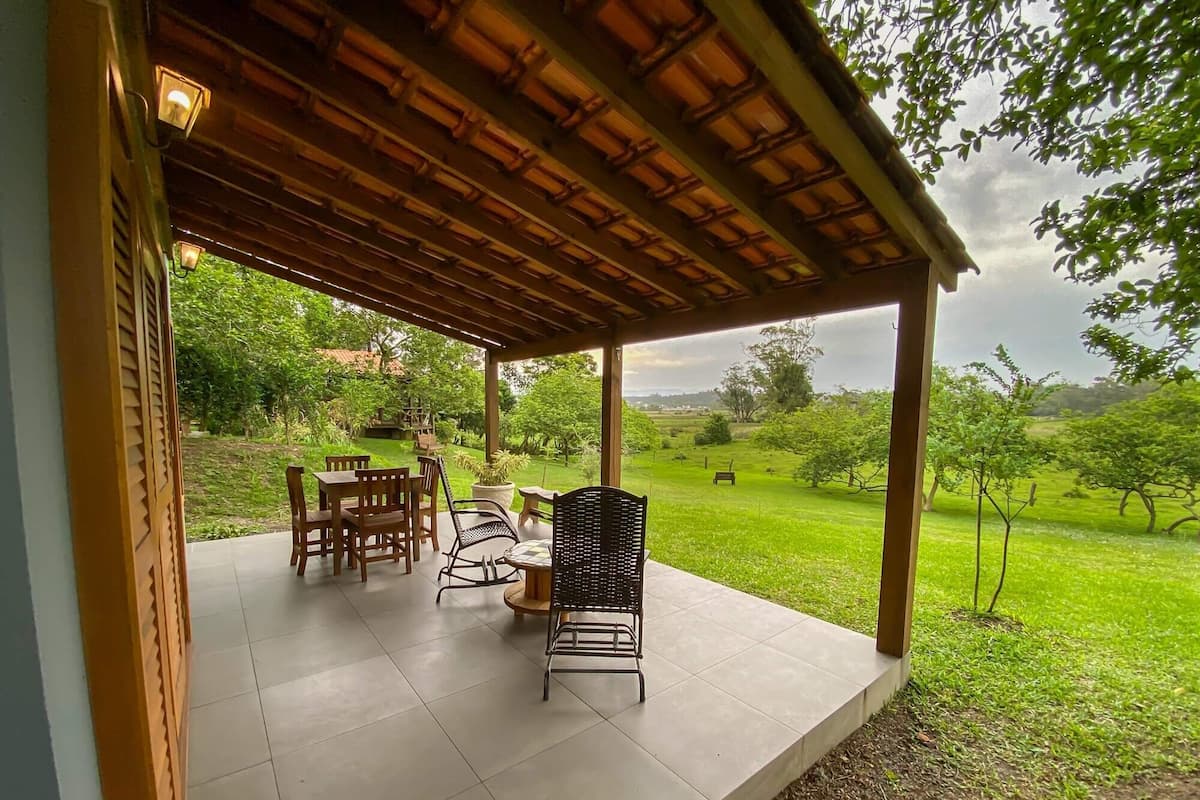 Une terrasse extérieure avec des meubles en bois et une vue sur un paysage verdoyant.