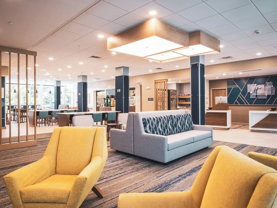 Un vestíbulo moderno con zonas de estar, mostrador de recepción y cafetería.