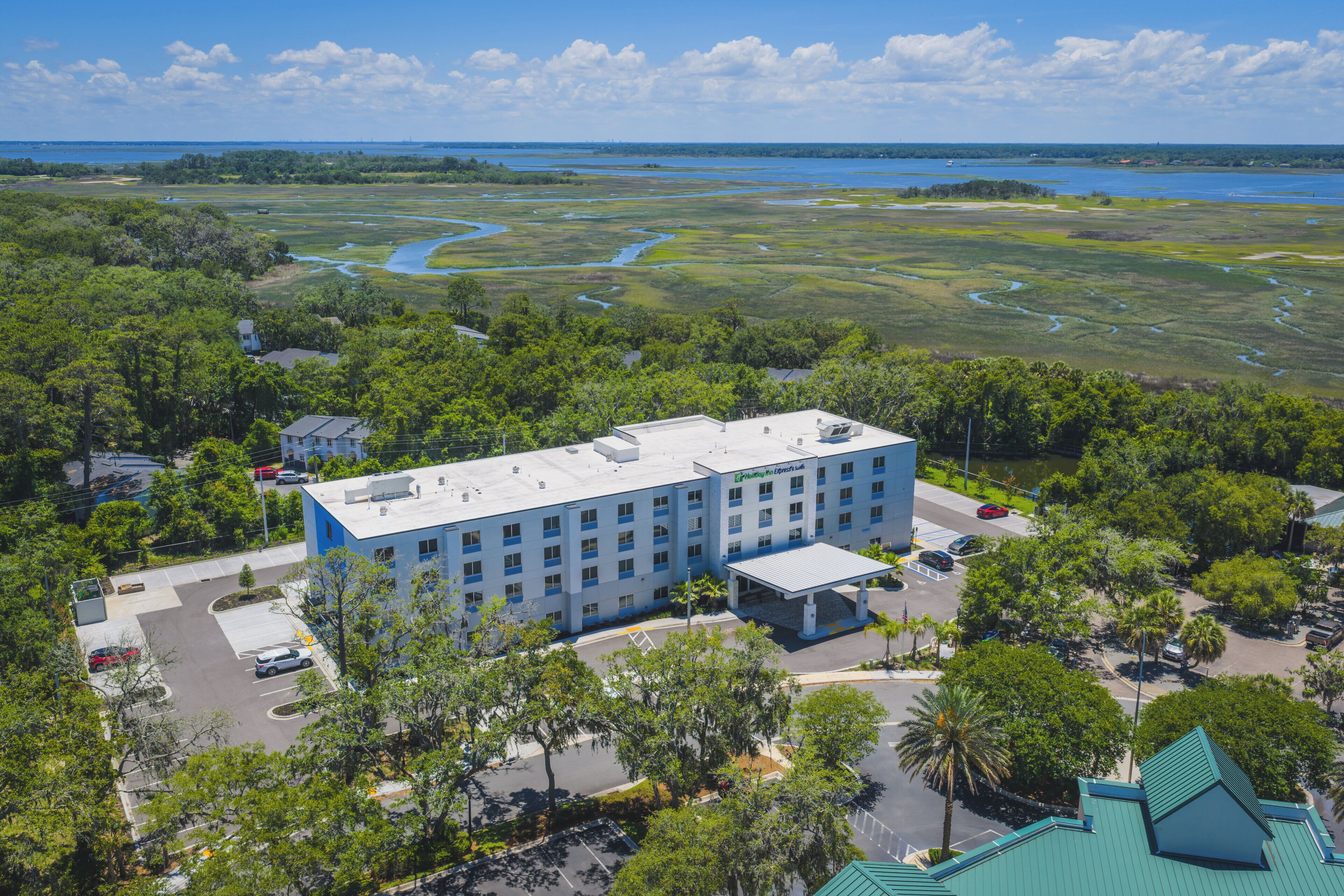Ein mehrstöckiges Hotel mit flachem Dach, umgeben von üppiger Vegetation und Blick auf einen Fluss.