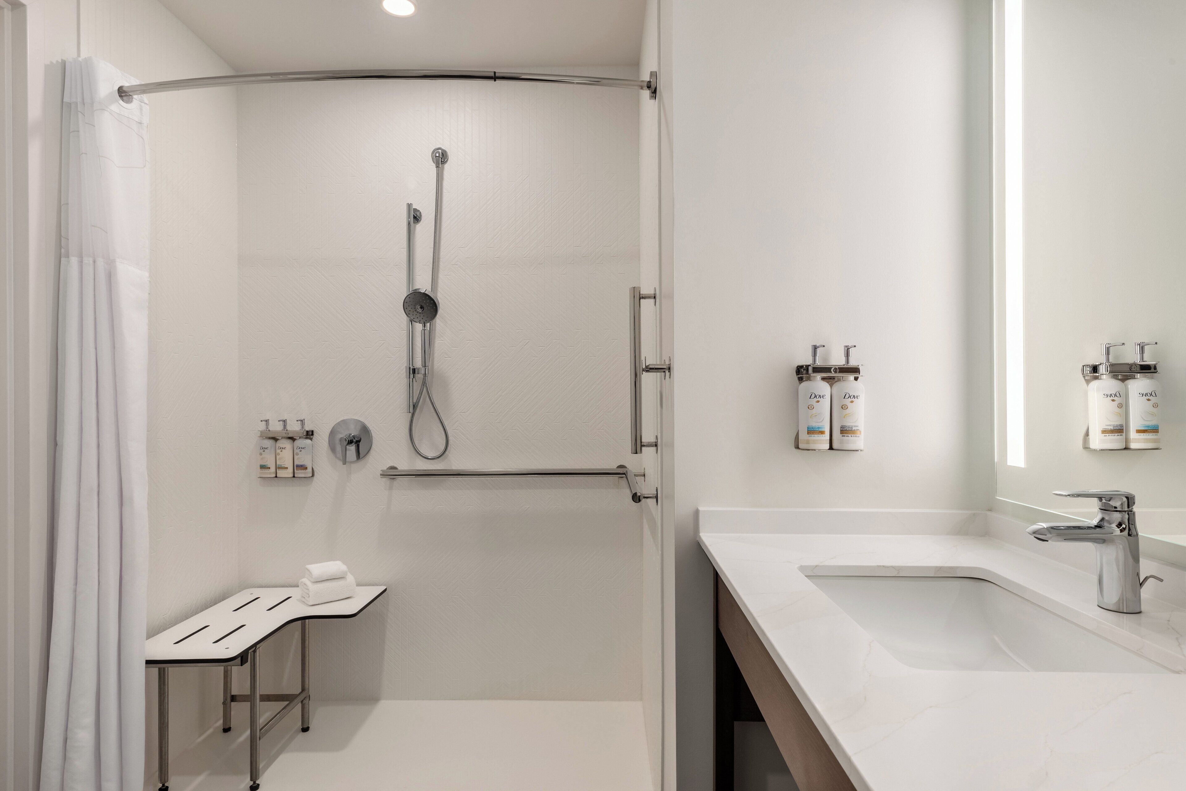 Uma casa de banho moderna com chuveiro, lavatório e artigos de higiene pessoal.