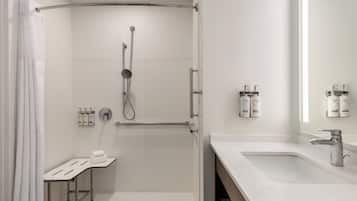 Uma casa de banho moderna com chuveiro, lavatório e artigos de higiene pessoal.