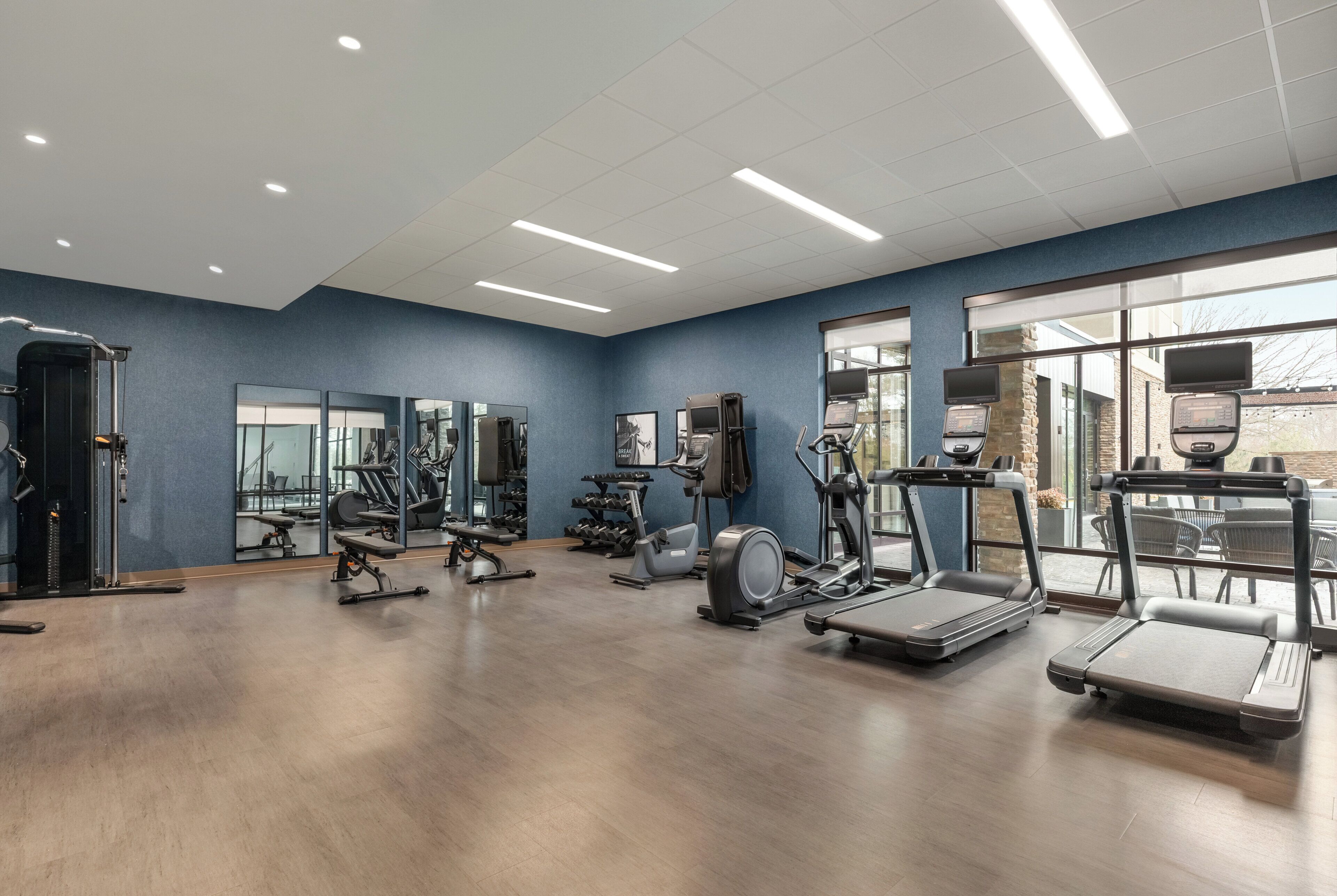 Una palestra con tapis roulant, macchinari ellittici e pesi liberi.