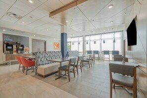 Un intérieur moderne avec des espaces de détente, un coin café et de grandes fenêtres.