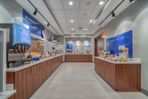 A modern breakfast area with a self-serve station, a bakery section, and a counter with various food items. - Holiday Inn Express Tyler South University Area by IHG (Tyler)