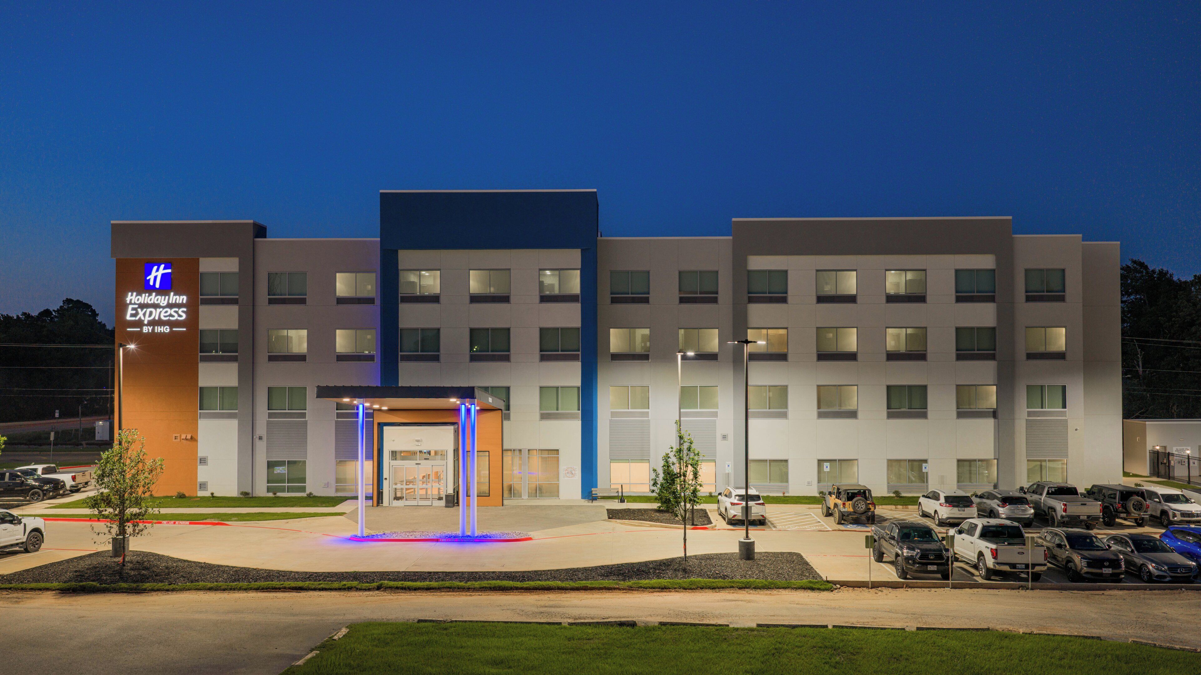 Un hôtel Holiday Inn Express doté d’une façade moderne, d’un parking et d’une fontaine décorative.
