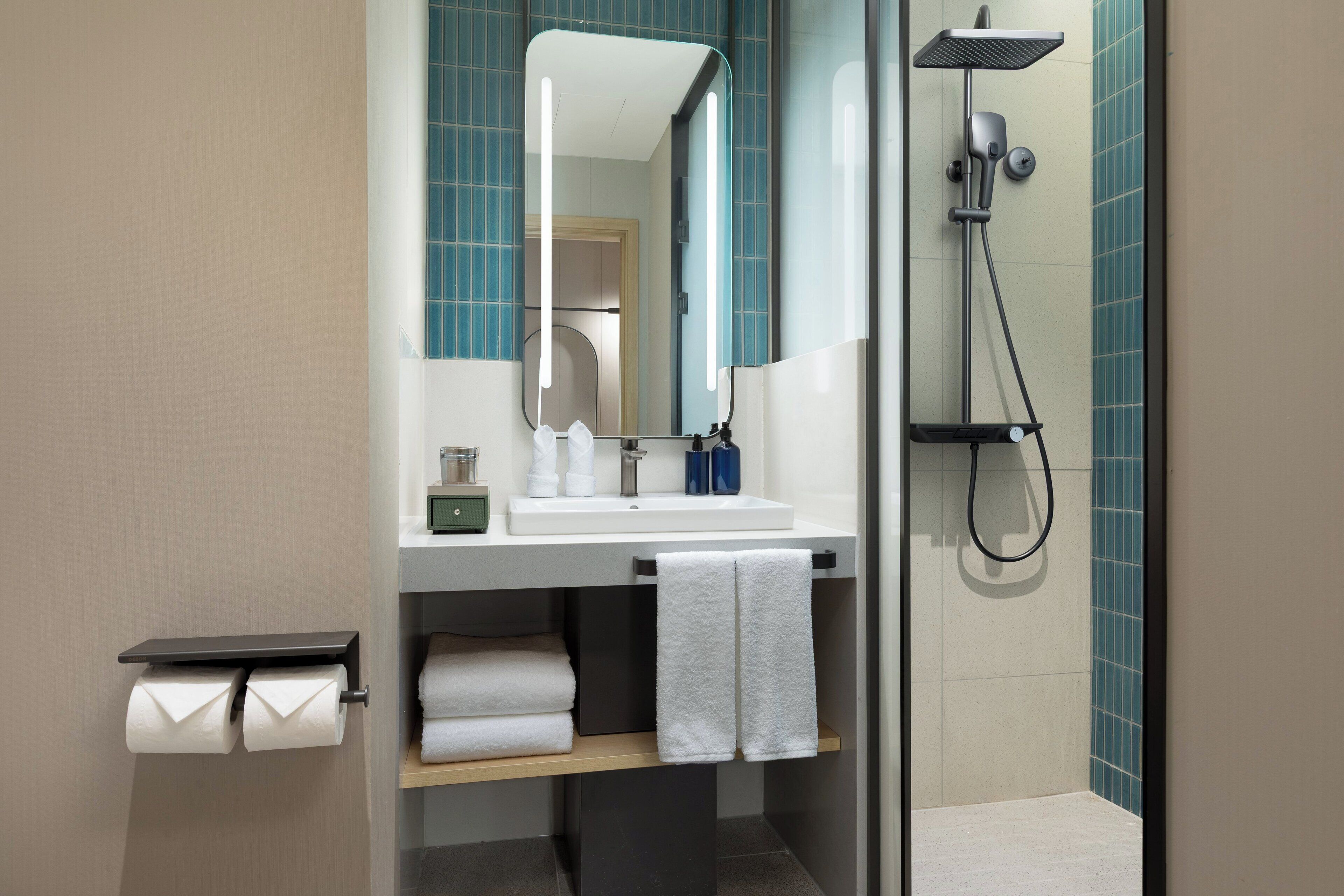 Une salle de bain moderne avec un lavabo, un miroir et une douche.