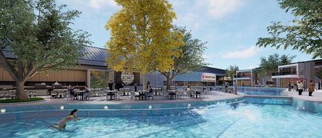 An outdoor pool area with tables and chairs, surrounded by trees and buildings.