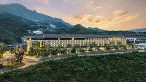 Een modern hotel met een lange gevel, meerdere verdiepingen en een plat dak.