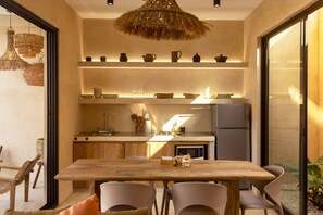 Eine moderne Küche mit Holztisch, Stühlen und einer Pendelleuchte.