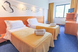A hotel room with two beds, a desk, a chair, a TV, and a window with curtains. - HOTEL PLANET INTERNATIONAL (Arezzo)