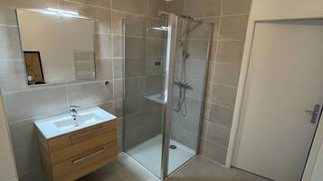 Een douche, een haardroger, handdoeken, toiletpapier