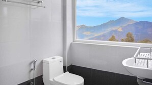 Een badkamer met een toilet, een douche en een wastafel.