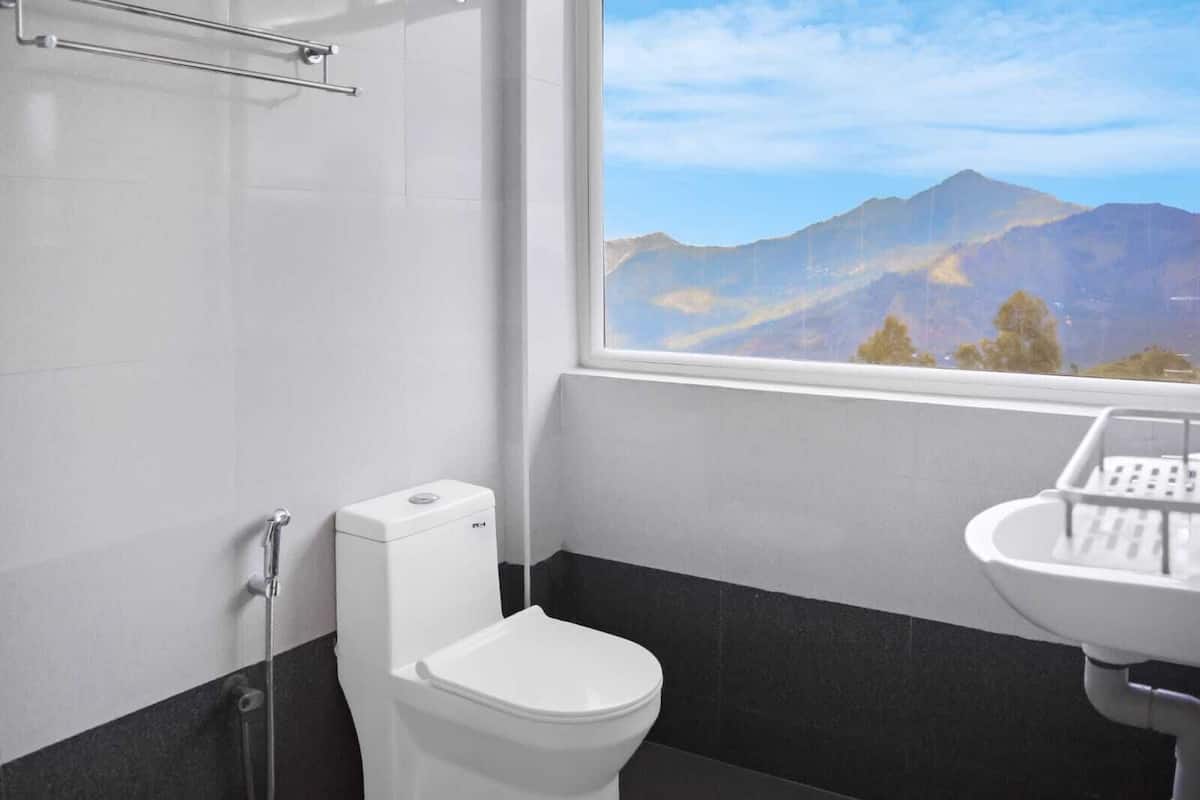A bathroom with a toilet, a shower, and a sink.