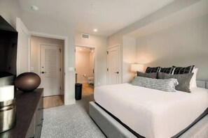 A modern bedroom with a large bed, bedside tables, and a wardrobe. - Kindred Resort Luxury Ski In, Ski Out 3 Bedroom Residence at the River Run Gondola (Keystone)