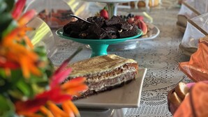 A buffet table with various food items and a decorative centerpiece. - Pousada Três Coqueiros (Angra dos Reis)