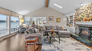 A spacious living room with a large sectional sofa, a fireplace, and a view of the outdoors.