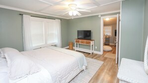 A bedroom with two beds, a ceiling fan, a TV, and a wicker chair. - Charming 4-bedroom house on Lake Hamilton! (Hot Springs)