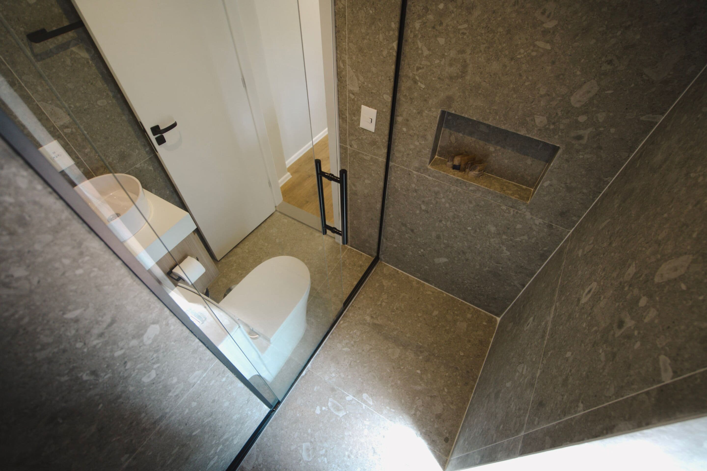 Une salle de bain comprenant des toilettes, un espace douche et un petit coin avec un porte-serviettes.