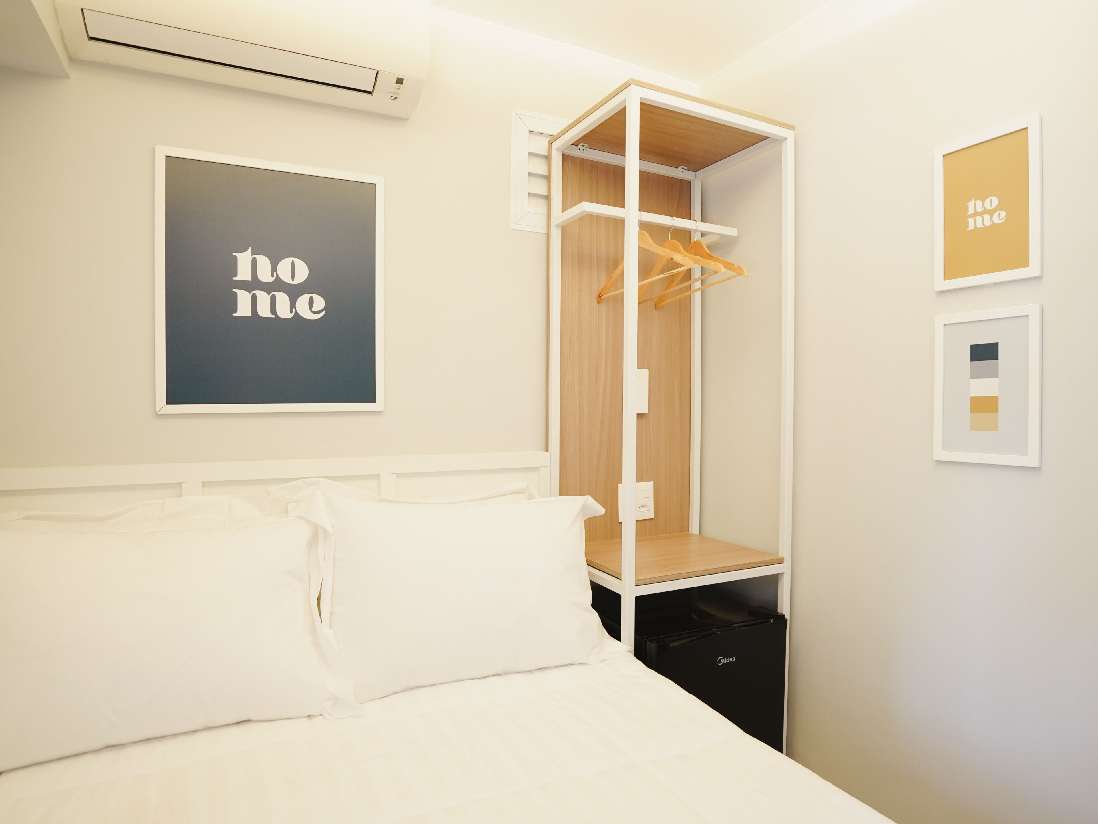 A bedroom with a bed, a wardrobe, and a 'home' sign on the wall.