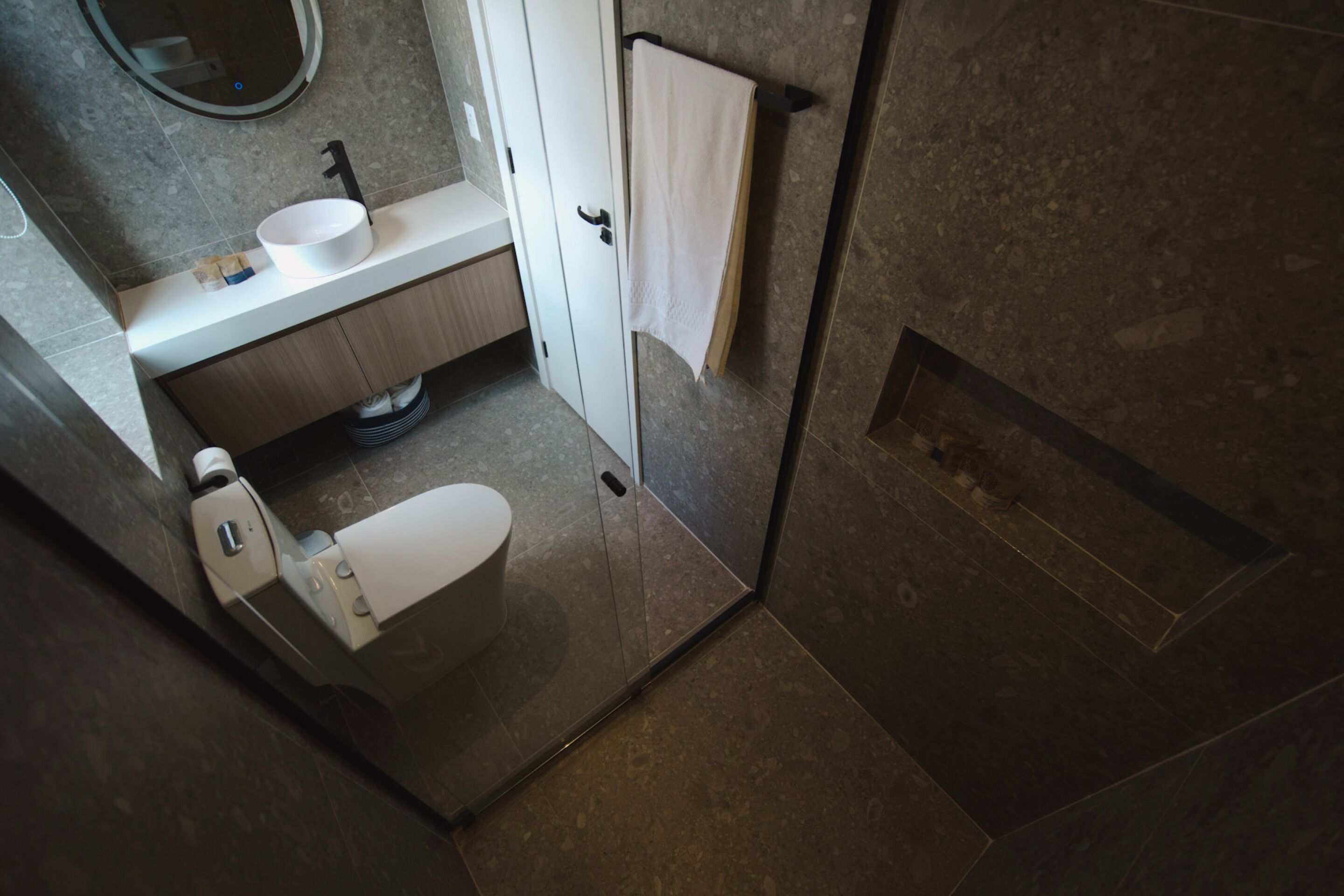 Un bany modern amb vàter, rentapel i porta tovalloles.
