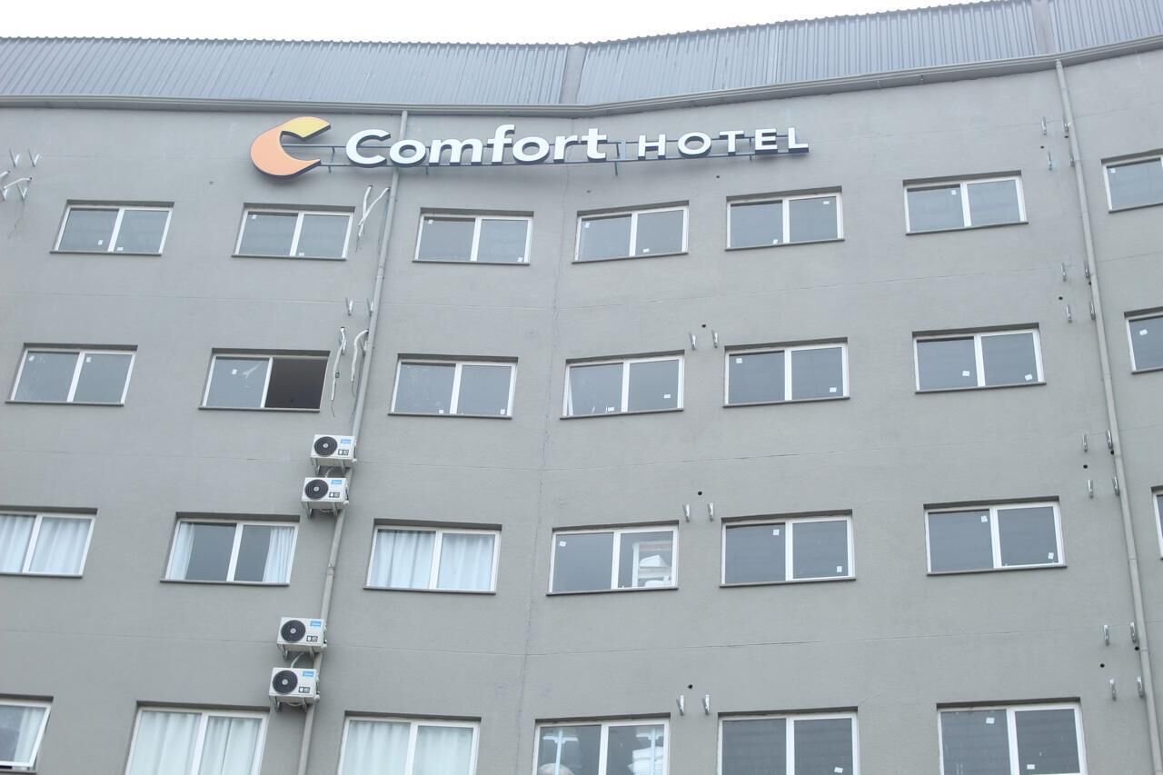 A multi-story building with a sign reading 'Comfort Hotel.'
