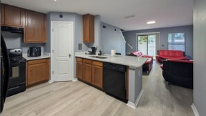 Una cocina moderna con armarios de madera, lavavajillas y refrigerador.