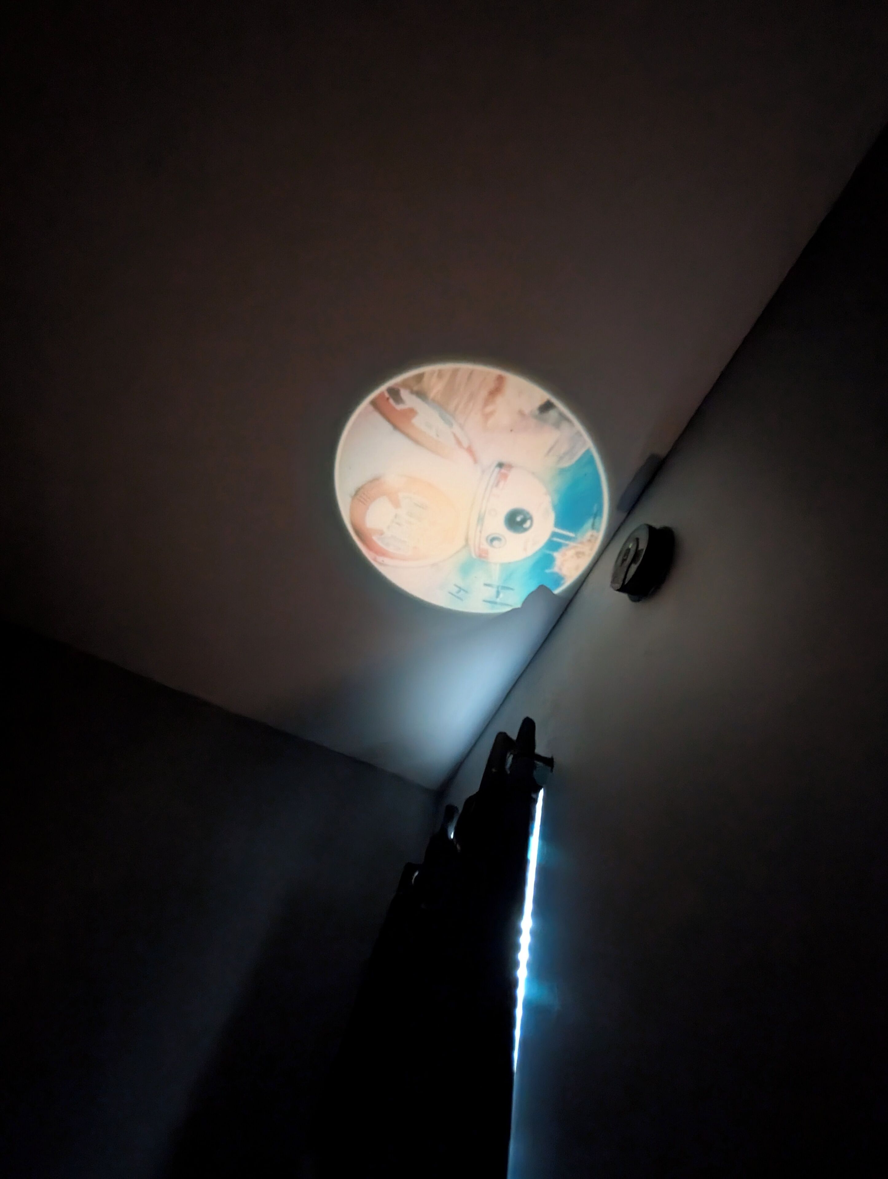 A ceiling with a circular light fixture and a small clock.
