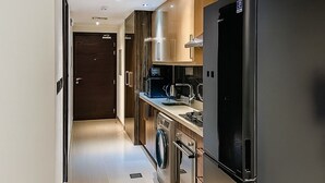 Eine moderne Küche mit einem schwarzen Kühlschrank, einer Waschmaschine und einem Herd.