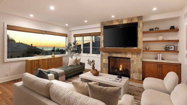 A modern living room with a fireplace, large windows, and a flat-screen TV. - Luxury 3-bedroom house near the pier in San Clemente (San Clemente)