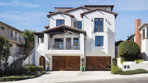 A two-story house with a wooden front door, a balcony, and a garage. - Luxury 3-bedroom house near the pier in San Clemente (San Clemente)