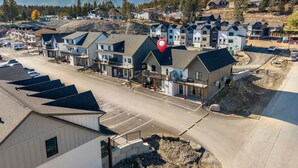 A residential area with multiple two-story houses, a parking lot, and a construction site. - Summit Stay | Ground Floor | Central | AC | Pets (Invermere)