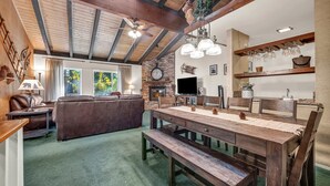 Ein gemütliches Wohnzimmer mit einem großen Holztisch, einer Ledersofa und einem Kamin.
